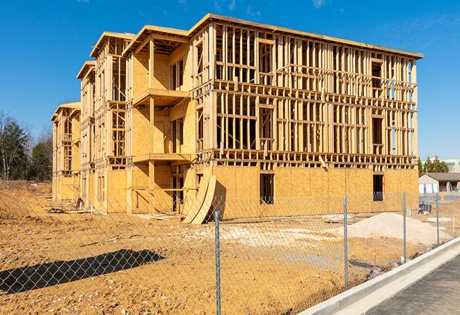 workers protected by temporary barrier fence during building maintenance in Edneyville